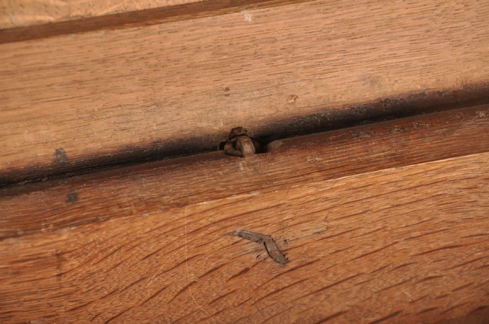 A 17th-century dark oak coffer with three carved arcaded front panels, an upper carved frieze, and a central iron lock plate. View XI