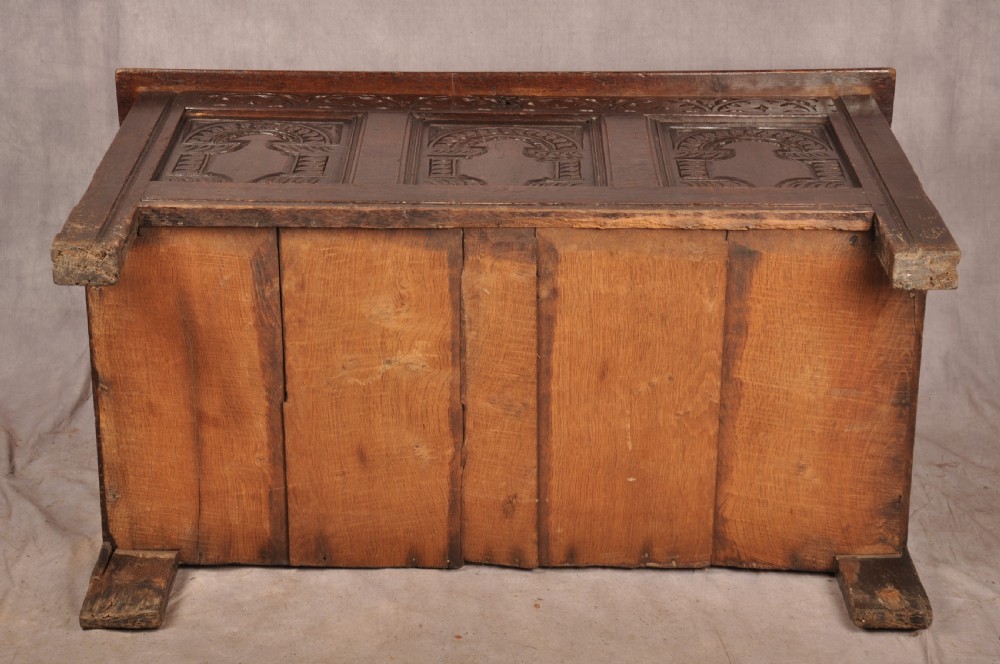 A 17th-century dark oak coffer with three carved arcaded front panels, an upper carved frieze, and a central iron lock plate. View XIV