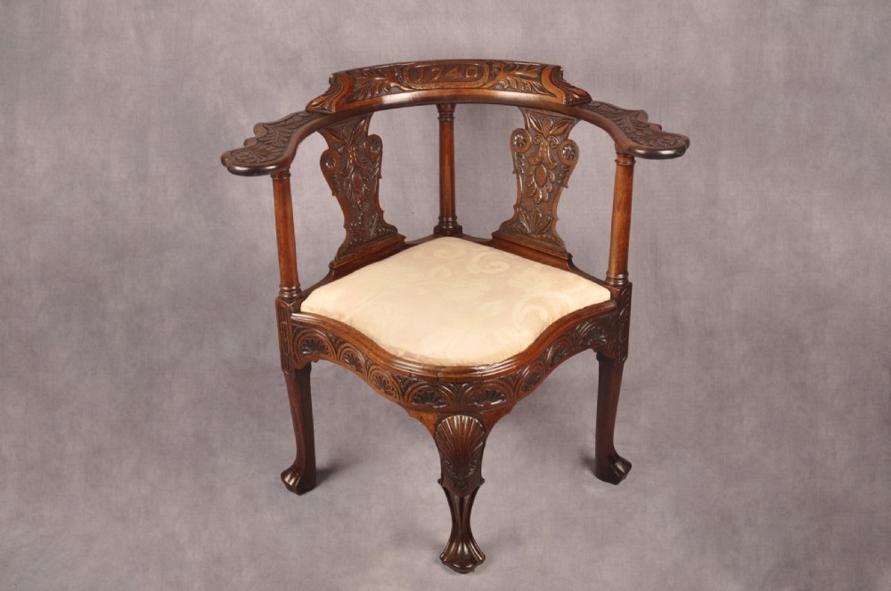 An 18th-century carved mahogany corner desk chair featuring detailed back splats, a shell-carved knee, cabriole legs, and a cream upholstered drop-in seat. View II