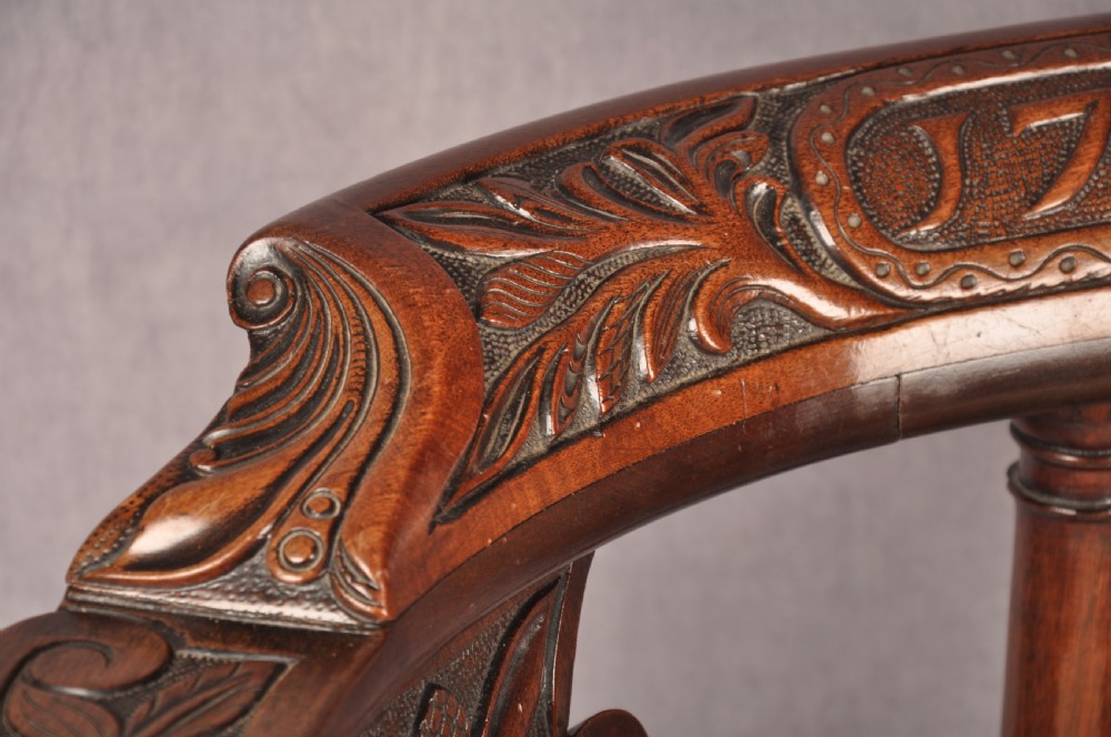 An 18th-century carved mahogany corner desk chair featuring detailed back splats, a shell-carved knee, cabriole legs, and a cream upholstered drop-in seat. View VII