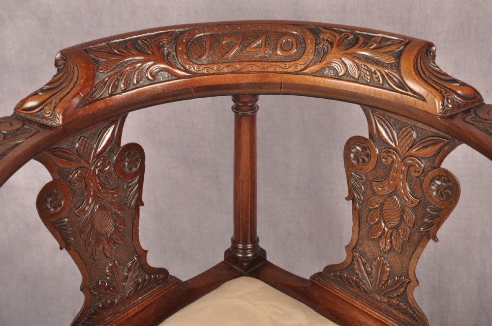 An 18th-century carved mahogany corner desk chair featuring detailed back splats, a shell-carved knee, cabriole legs, and a cream upholstered drop-in seat. View VIII