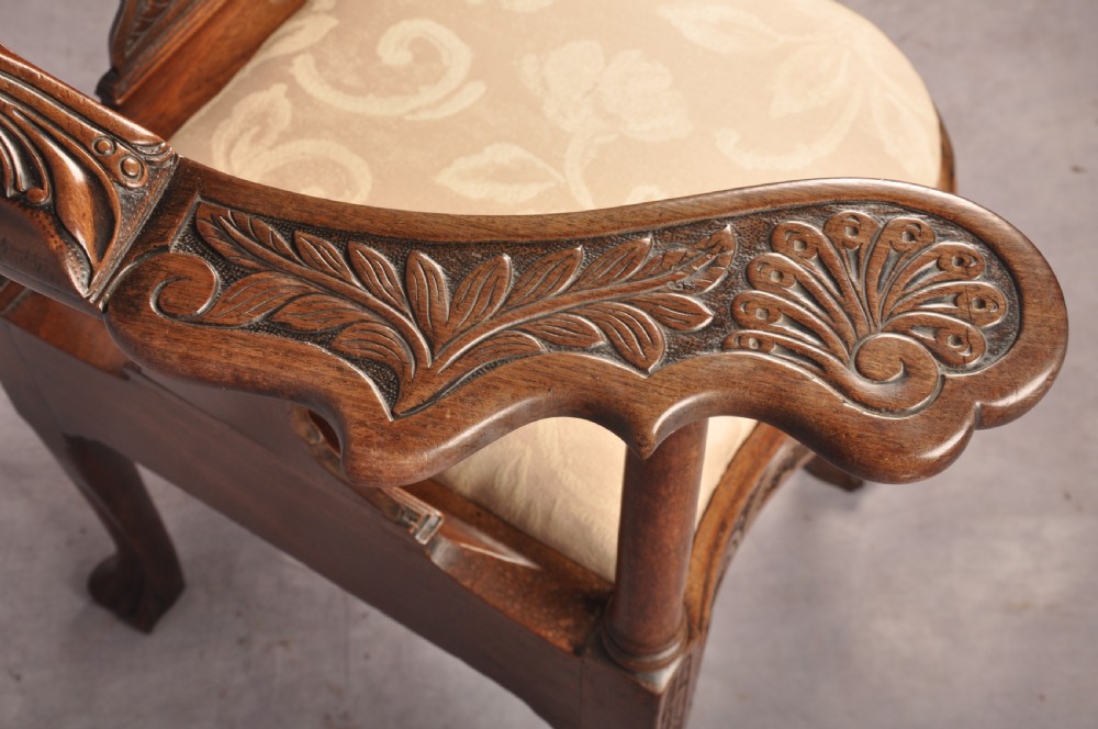 An 18th-century carved mahogany corner desk chair featuring detailed back splats, a shell-carved knee, cabriole legs, and a cream upholstered drop-in seat. View IX