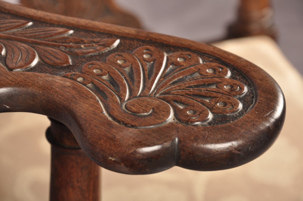 An 18th-century carved mahogany corner desk chair featuring detailed back splats, a shell-carved knee, cabriole legs, and a cream upholstered drop-in seat. View X