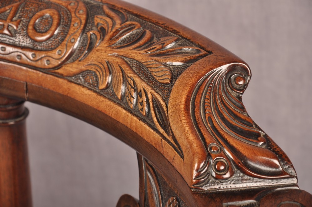 An 18th-century carved mahogany corner desk chair featuring detailed back splats, a shell-carved knee, cabriole legs, and a cream upholstered drop-in seat. View XII