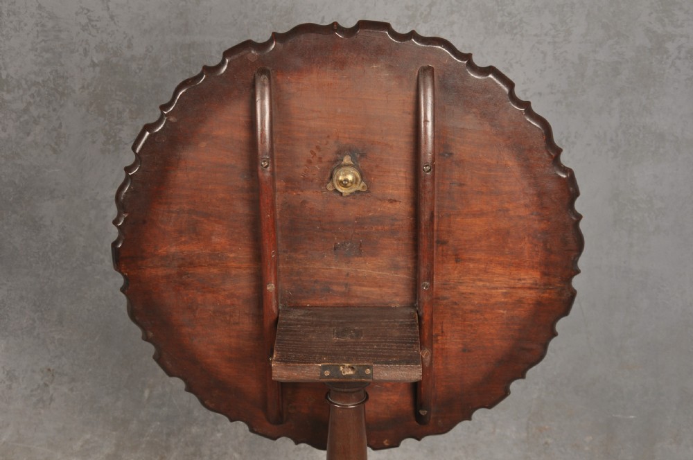 An 18th-century mahogany tripod table featuring a circular scalloped piecrust top, a turned column, and three cabriole legs ending in carved feet. View VII
