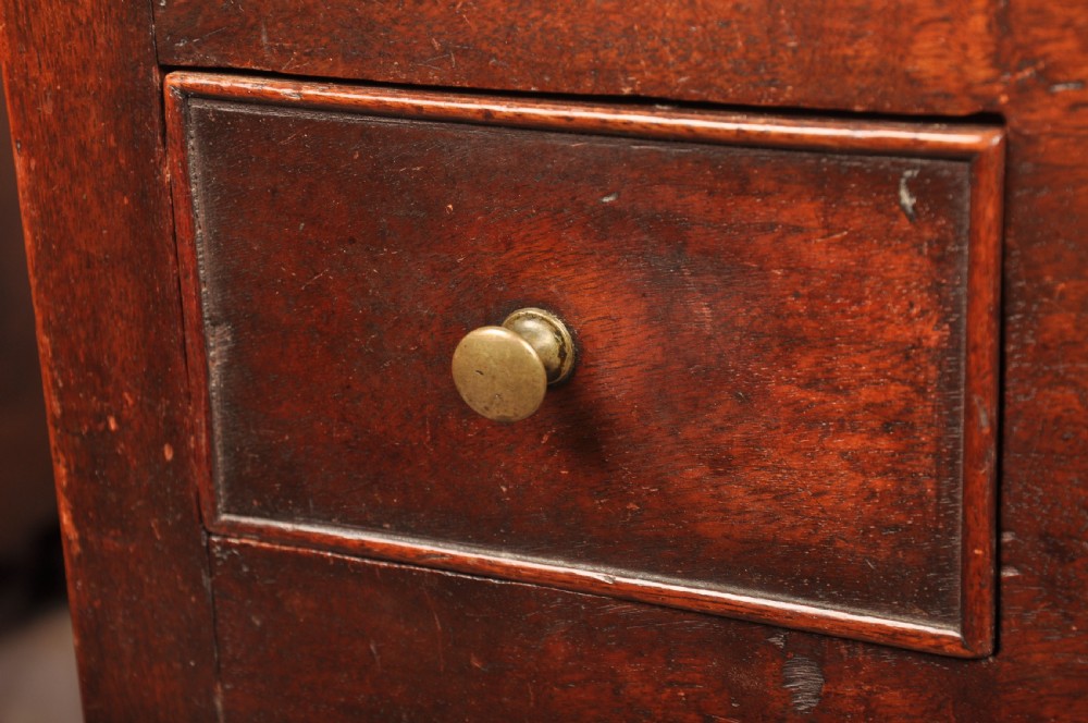 An early 18th-century dark walnut lowboy side table featuring cabriole legs with pad feet, three brass-handled drawers, and a shaped apron. View III