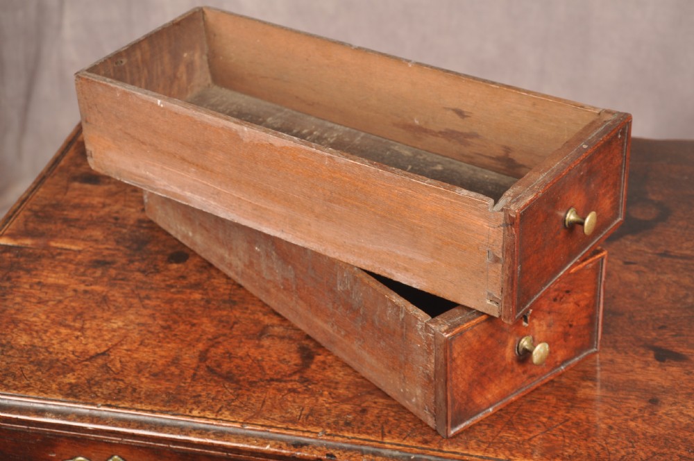 An early 18th-century dark walnut lowboy side table featuring cabriole legs with pad feet, three brass-handled drawers, and a shaped apron. View VII