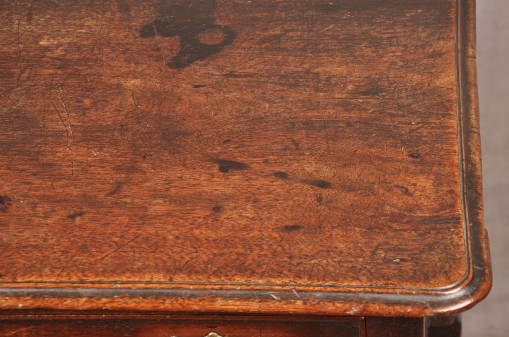 An early 18th-century dark walnut lowboy side table featuring cabriole legs with pad feet, three brass-handled drawers, and a shaped apron. View VIII