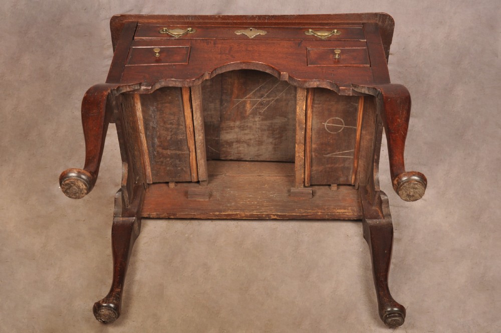 An early 18th-century dark walnut lowboy side table featuring cabriole legs with pad feet, three brass-handled drawers, and a shaped apron. View XVI