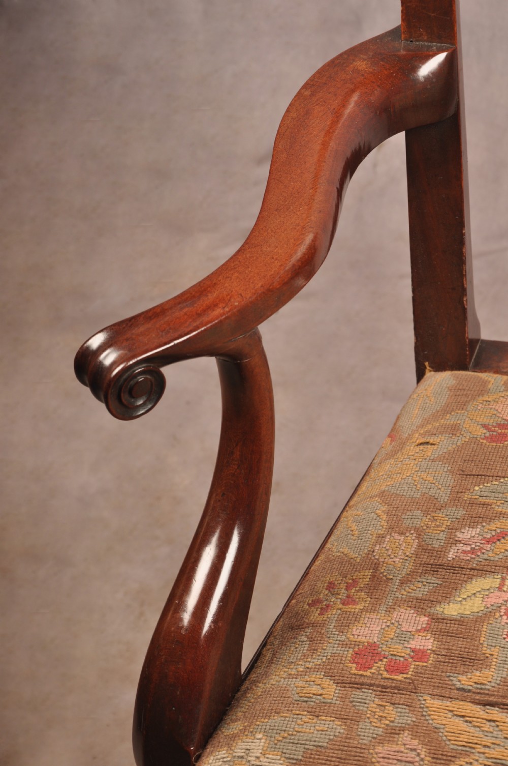 An 18th-century mahogany armchair with a carved pierced splat back, shaped arms, a tapestry-upholstered seat, and cabriole front legs ending in ball and claw feet. View V