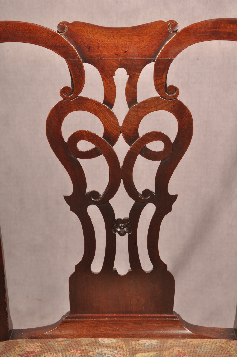 An 18th-century mahogany armchair with a carved pierced splat back, shaped arms, a tapestry-upholstered seat, and cabriole front legs ending in ball and claw feet. View IX