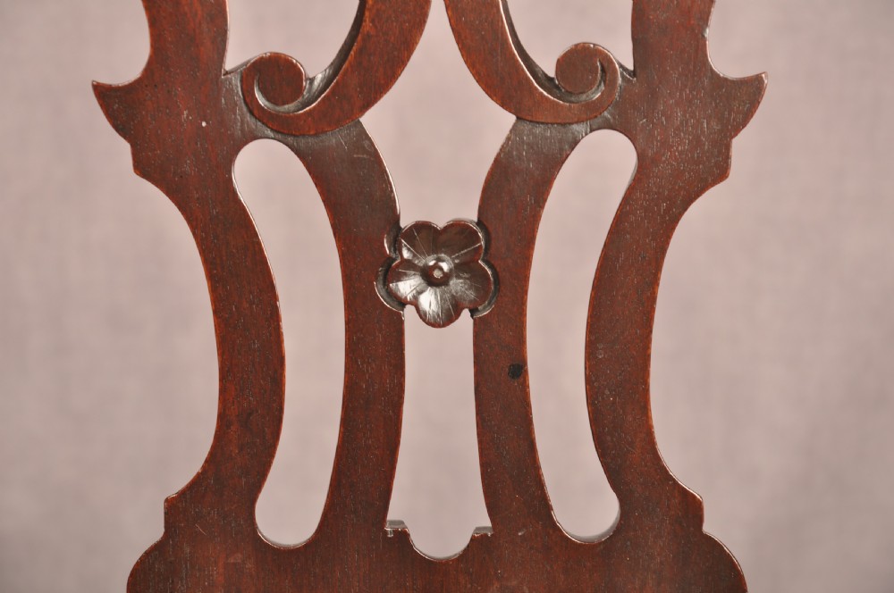 An 18th-century mahogany armchair with a carved pierced splat back, shaped arms, a tapestry-upholstered seat, and cabriole front legs ending in ball and claw feet. View X