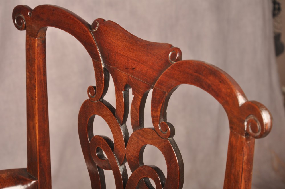 An 18th-century mahogany armchair with a carved pierced splat back, shaped arms, a tapestry-upholstered seat, and cabriole front legs ending in ball and claw feet. View XIII