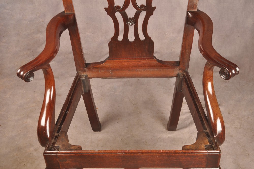 An 18th-century mahogany armchair with a carved pierced splat back, shaped arms, a tapestry-upholstered seat, and cabriole front legs ending in ball and claw feet. View XVIII