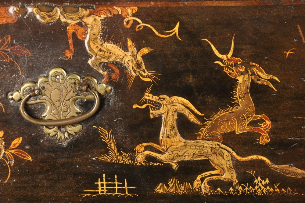 An early eighteenth-century black and gold japanned chest on stand featuring detailed Chinoiserie scenes, multiple brass drop handles, turned legs, and a shaped stretcher. View VI