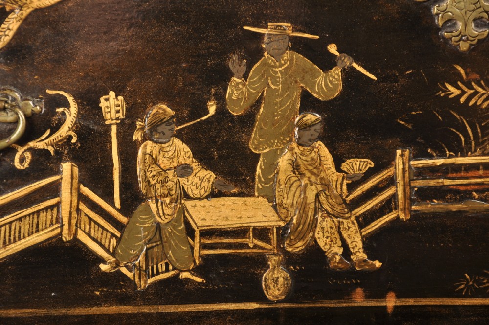An early eighteenth-century black and gold japanned chest on stand featuring detailed Chinoiserie scenes, multiple brass drop handles, turned legs, and a shaped stretcher. View VIII