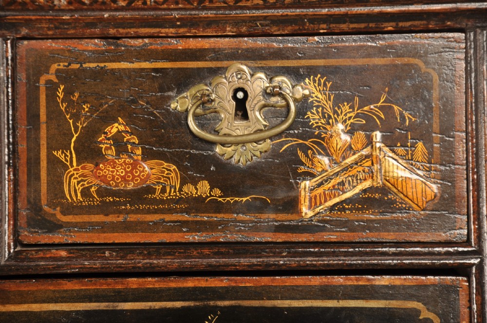 An early eighteenth-century black and gold japanned chest on stand featuring detailed Chinoiserie scenes, multiple brass drop handles, turned legs, and a shaped stretcher. View IX