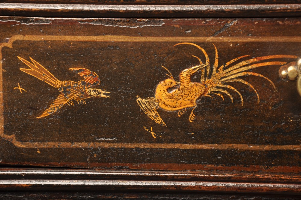 An early eighteenth-century black and gold japanned chest on stand featuring detailed Chinoiserie scenes, multiple brass drop handles, turned legs, and a shaped stretcher. View XII