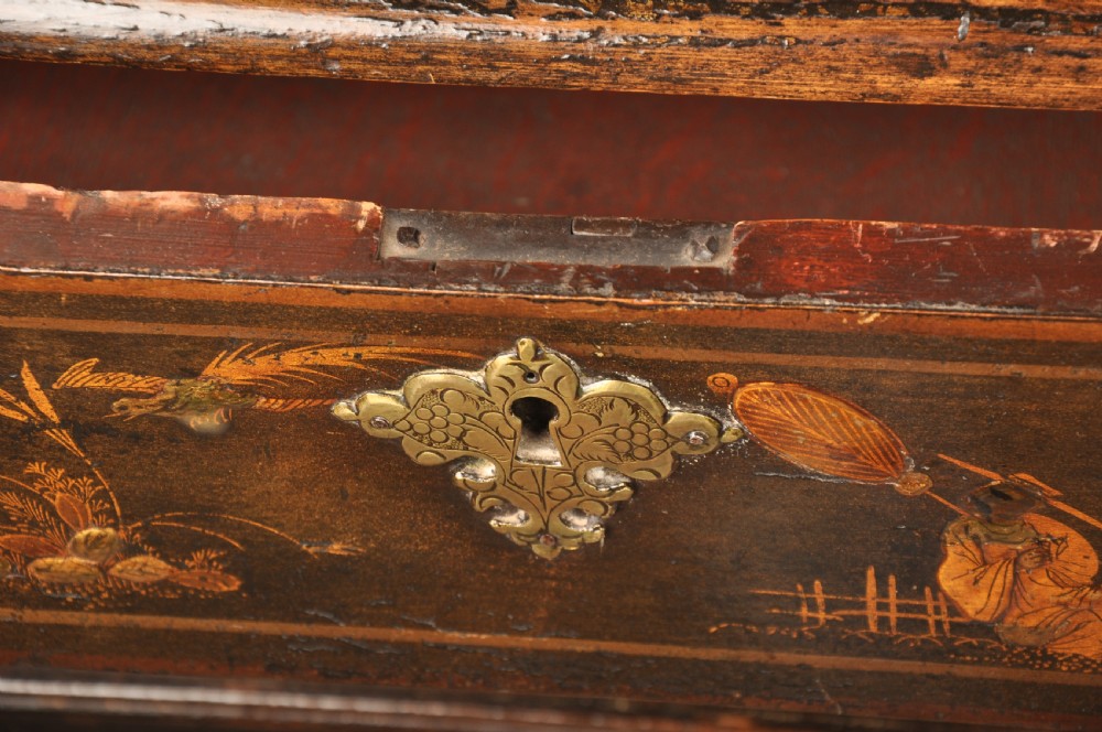 An early eighteenth-century black and gold japanned chest on stand featuring detailed Chinoiserie scenes, multiple brass drop handles, turned legs, and a shaped stretcher. View XIII