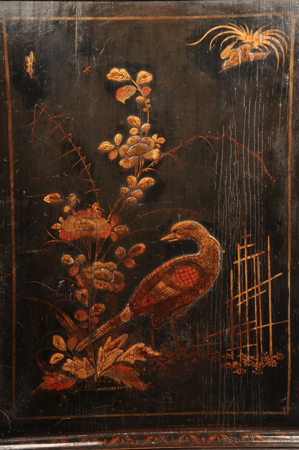 An early eighteenth-century black and gold japanned chest on stand featuring detailed Chinoiserie scenes, multiple brass drop handles, turned legs, and a shaped stretcher. View XXV