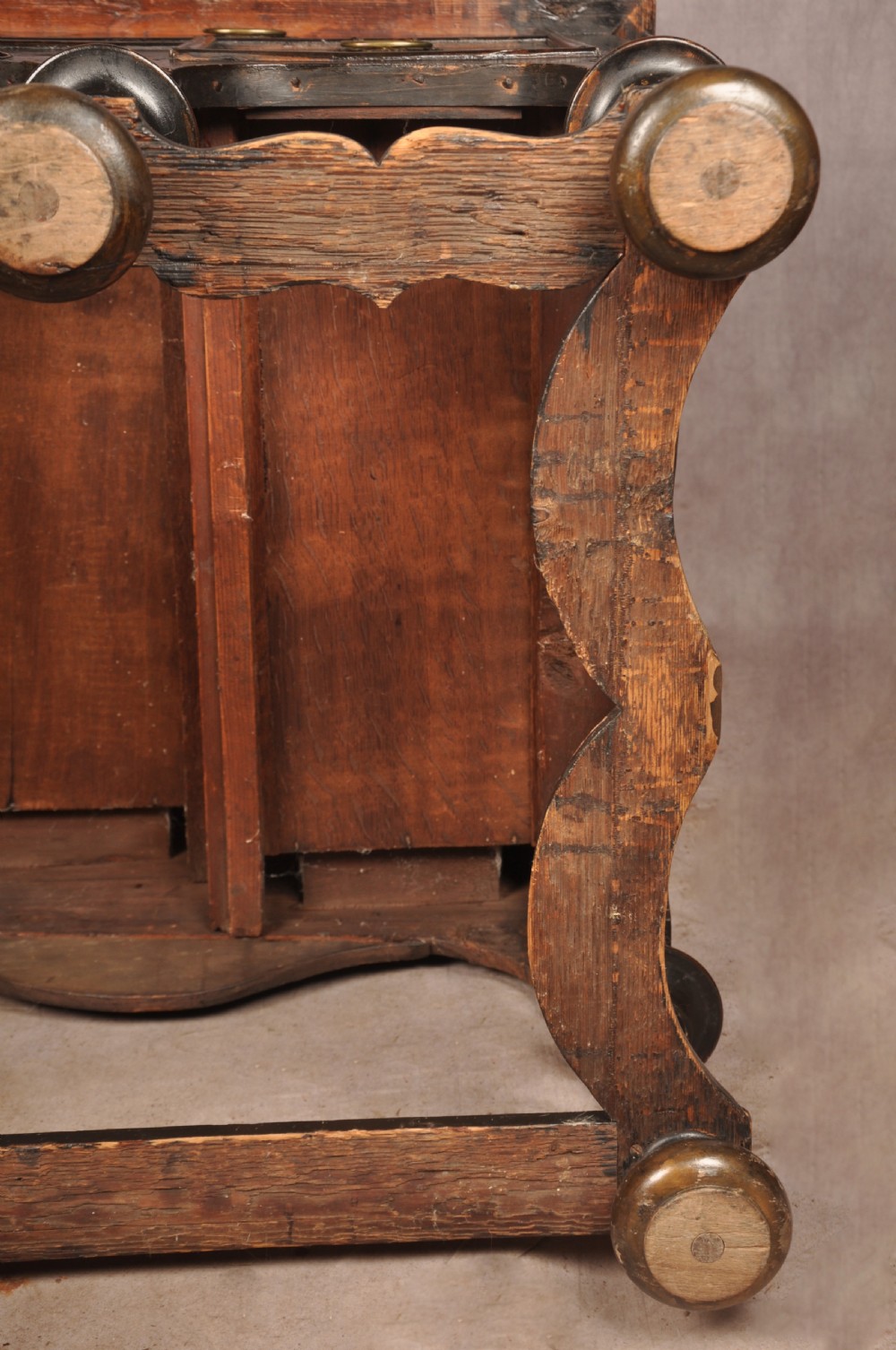 An early eighteenth-century black and gold japanned chest on stand featuring detailed Chinoiserie scenes, multiple brass drop handles, turned legs, and a shaped stretcher. View XXVII
