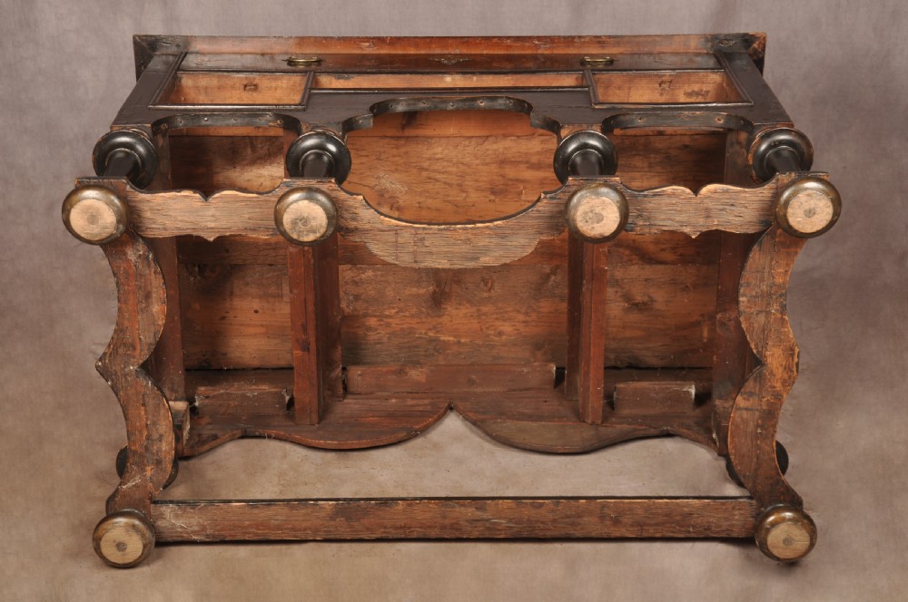 An early eighteenth-century black and gold japanned chest on stand featuring detailed Chinoiserie scenes, multiple brass drop handles, turned legs, and a shaped stretcher. View XXVIII