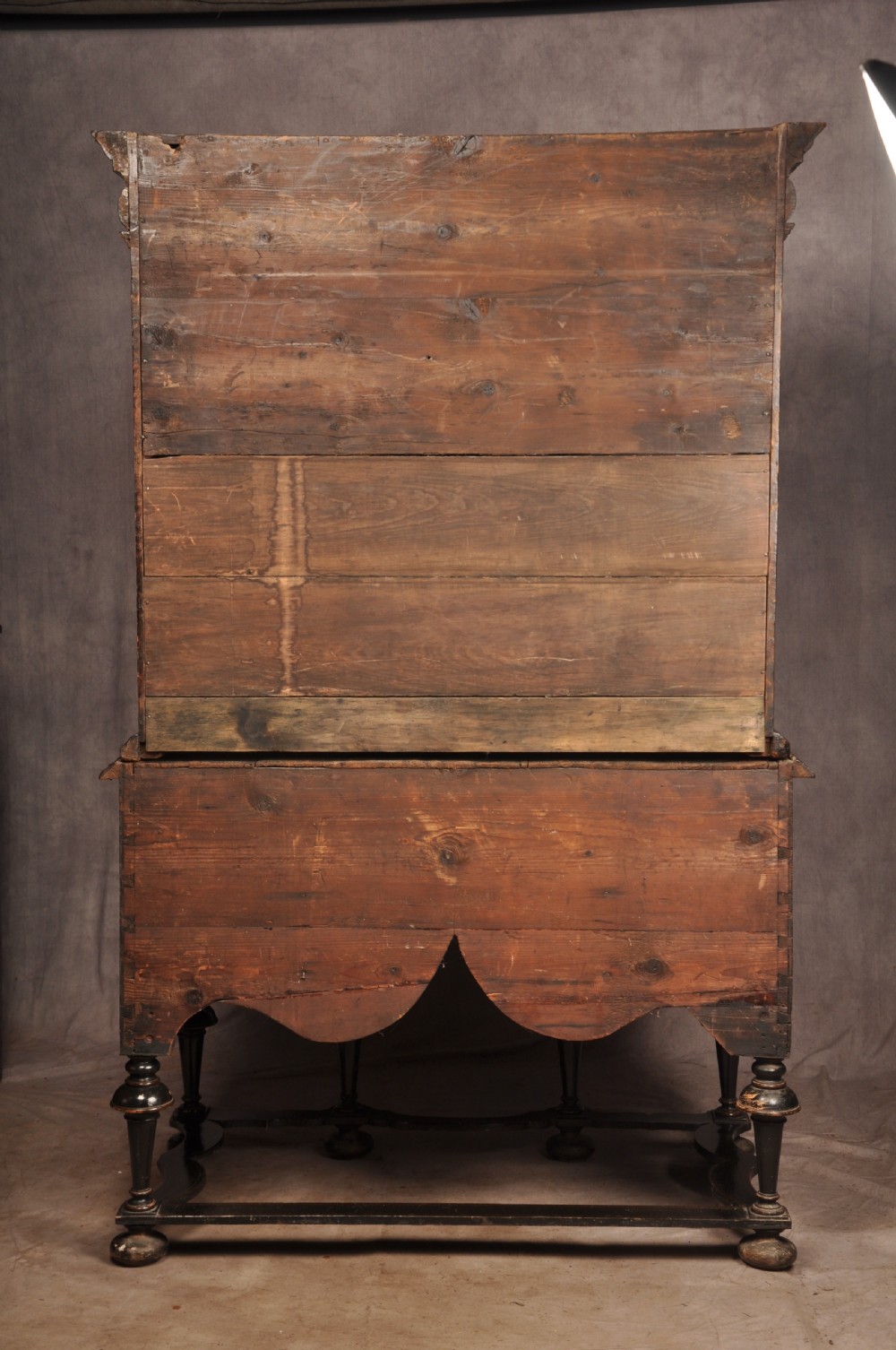 An early eighteenth-century black and gold japanned chest on stand featuring detailed Chinoiserie scenes, multiple brass drop handles, turned legs, and a shaped stretcher. View XXX