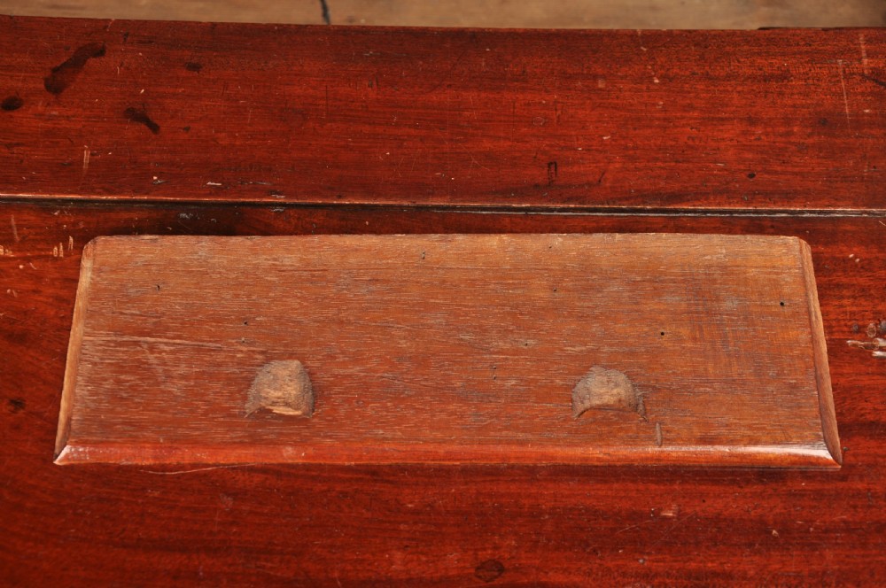 An early 18th-century mahogany slope-front bureau with three graduated drawers, brass handles, keyhole escutcheons, and bracket feet. View VI