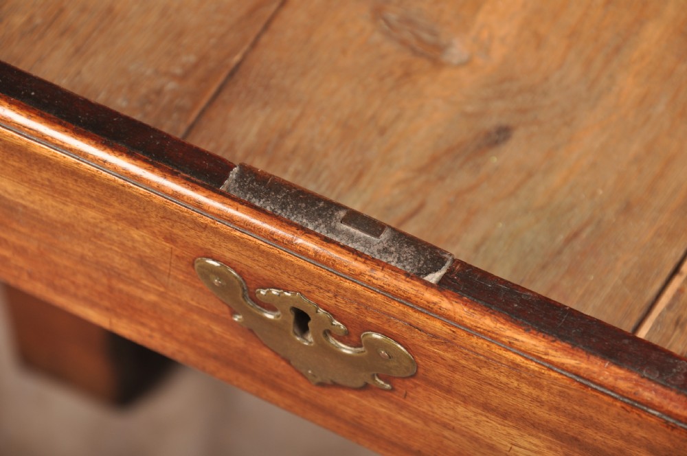 An early 18th-century mahogany slope-front bureau with three graduated drawers, brass handles, keyhole escutcheons, and bracket feet. View XIV