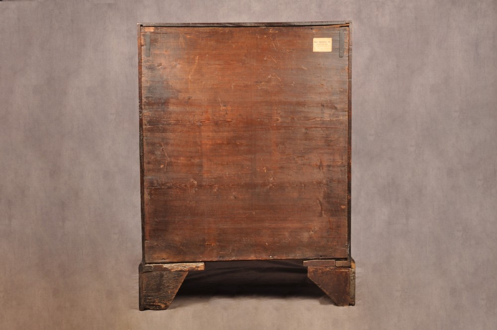 An early 18th-century mahogany slope-front bureau with three graduated drawers, brass handles, keyhole escutcheons, and bracket feet. View XVIII