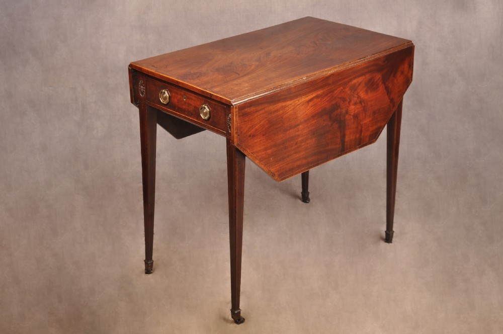 A late 18th-century mahogany Pembroke table with drop-leaf sides, square tapered legs on castors, and a single drawer with octagonal brass handles.