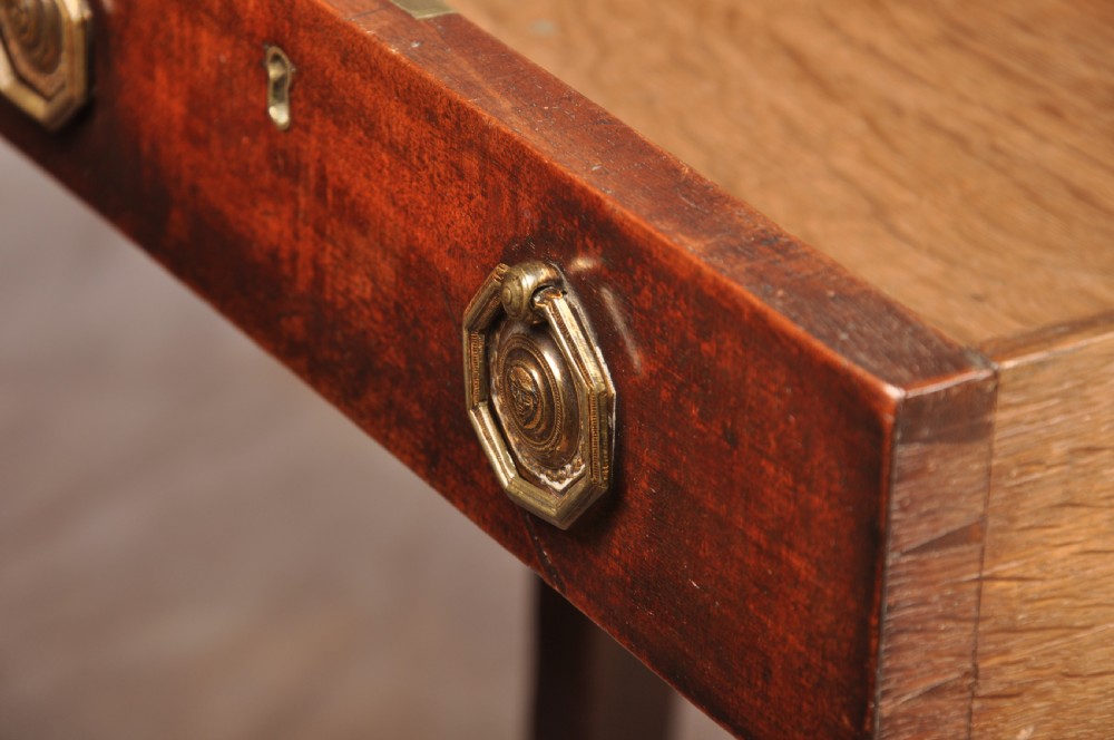 A late 18th-century mahogany Pembroke table with drop-leaf sides, square tapered legs on castors, and a single drawer with octagonal brass handles. View V