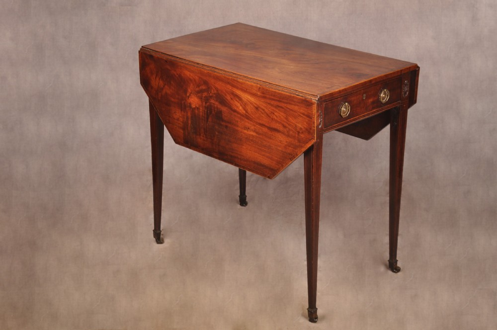 A late 18th-century mahogany Pembroke table with drop-leaf sides, square tapered legs on castors, and a single drawer with octagonal brass handles. View VI