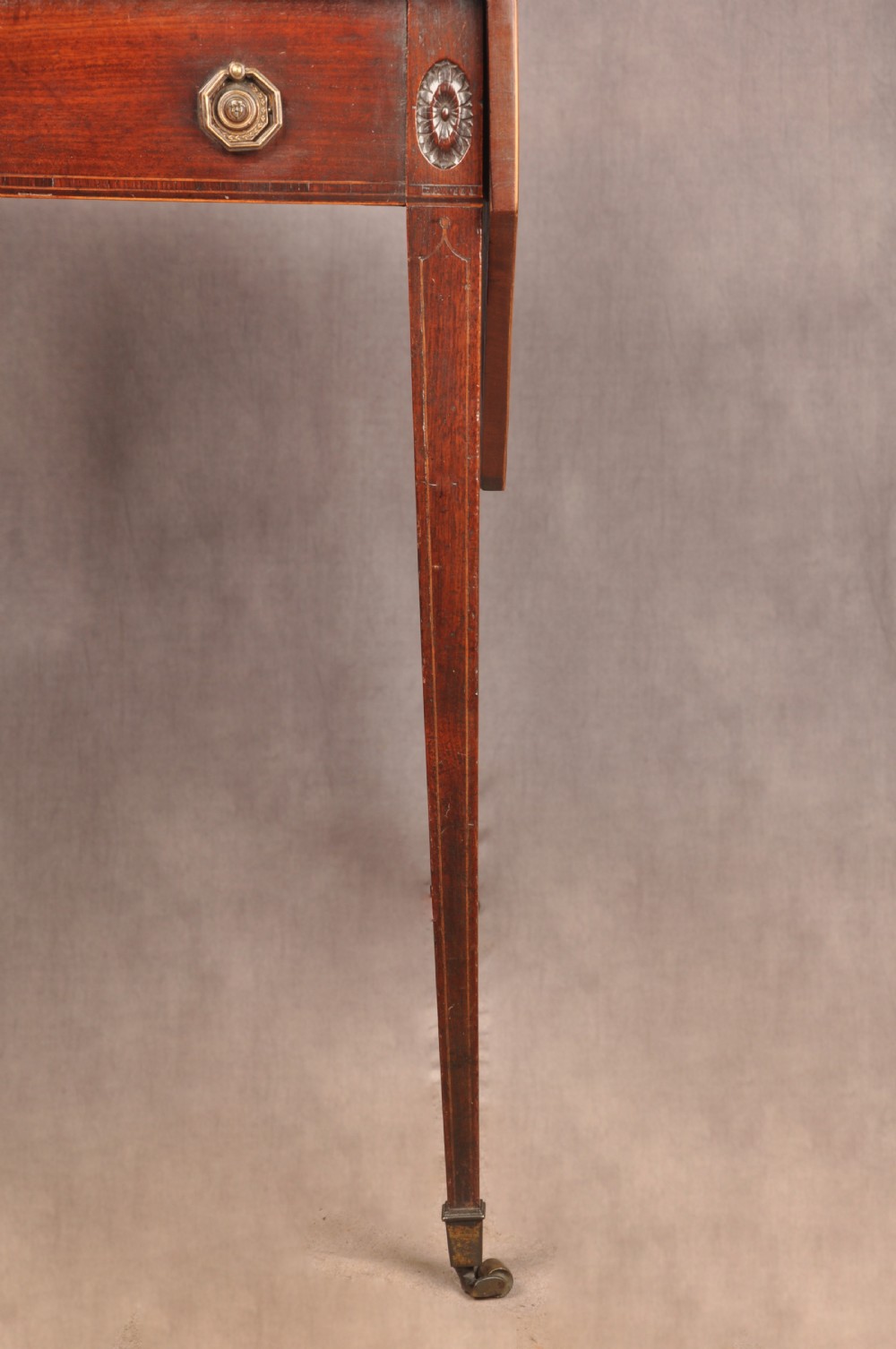A late 18th-century mahogany Pembroke table with drop-leaf sides, square tapered legs on castors, and a single drawer with octagonal brass handles. View IX
