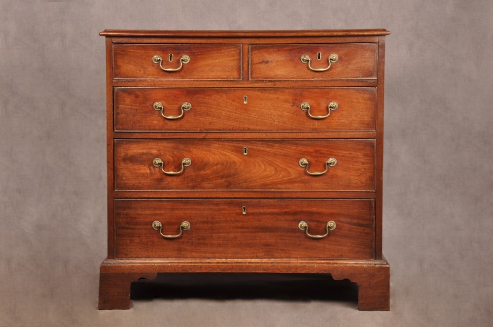 An 18th-century Georgian mahogany chest of drawers featuring two short over three long graduated drawers with brass swan-neck handles and bracket feet.