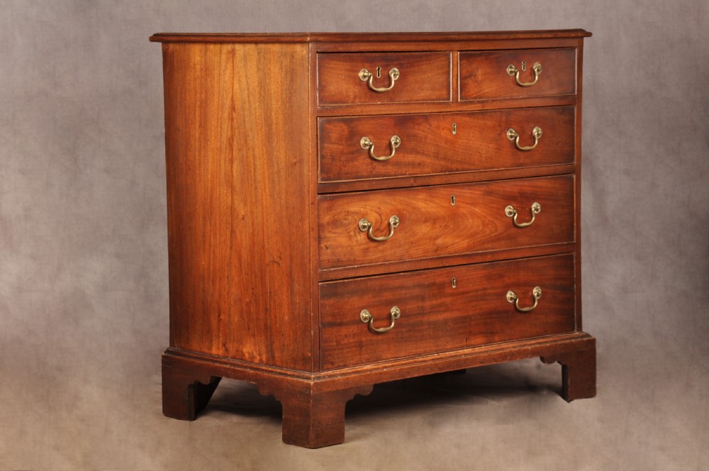 An 18th-century Georgian mahogany chest of drawers featuring two short over three long graduated drawers with brass swan-neck handles and bracket feet. View II