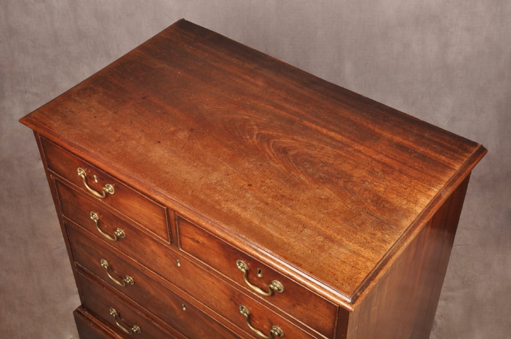 An 18th-century Georgian mahogany chest of drawers featuring two short over three long graduated drawers with brass swan-neck handles and bracket feet. View VI