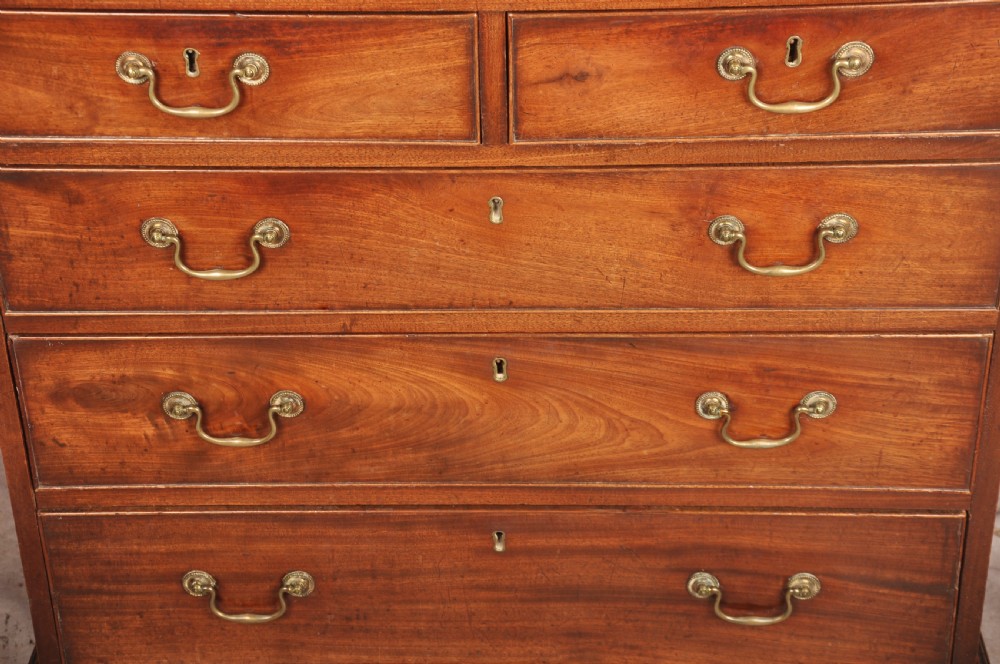 An 18th-century Georgian mahogany chest of drawers featuring two short over three long graduated drawers with brass swan-neck handles and bracket feet. View VII