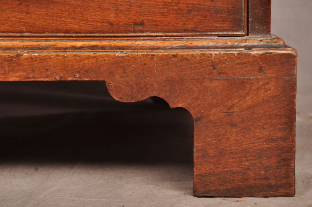 An 18th-century Georgian mahogany chest of drawers featuring two short over three long graduated drawers with brass swan-neck handles and bracket feet. View IX
