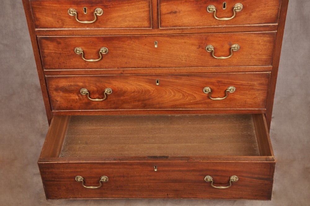 An 18th-century Georgian mahogany chest of drawers featuring two short over three long graduated drawers with brass swan-neck handles and bracket feet. View X