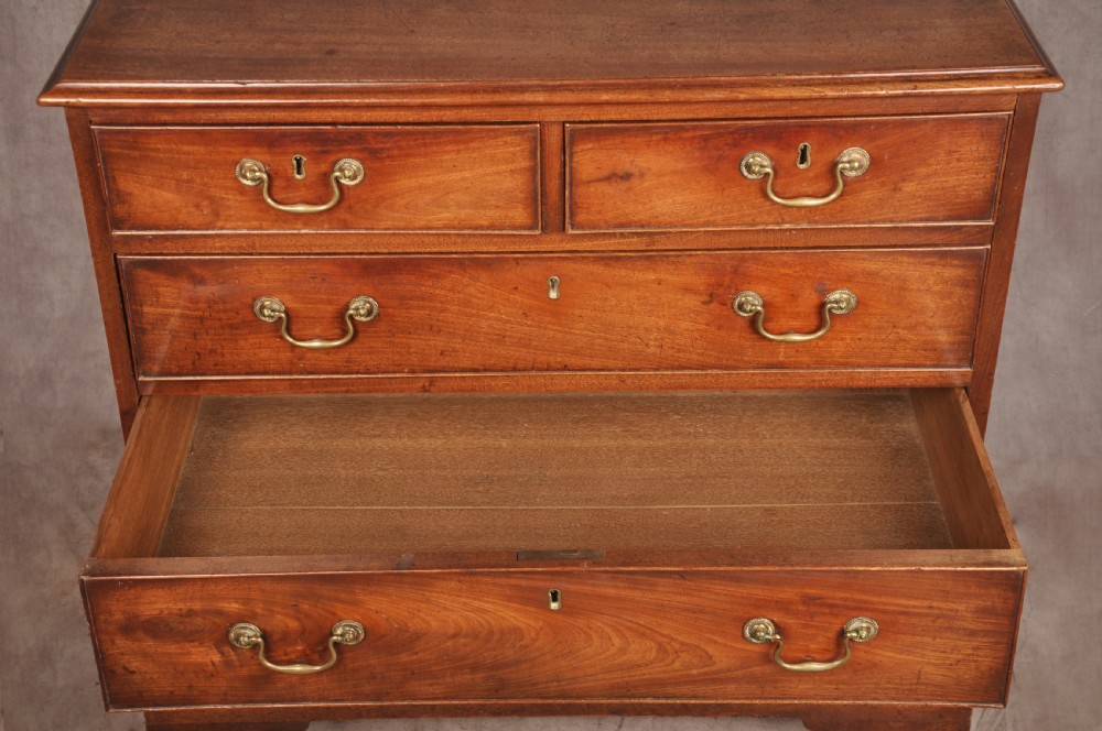 An 18th-century Georgian mahogany chest of drawers featuring two short over three long graduated drawers with brass swan-neck handles and bracket feet. View XI