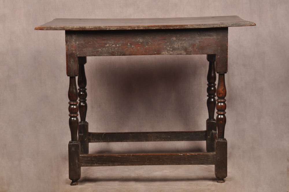 A 17th-century dark oak side table featuring a single drawer with a brass handle, turned legs, and a perimeter box stretcher. View XI