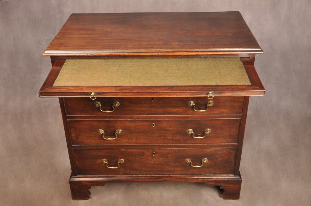 An eighteenth-century mahogany chest of drawers featuring four graduated drawers with brass swan-neck handles, a brushing slide, and bracket feet. View VI