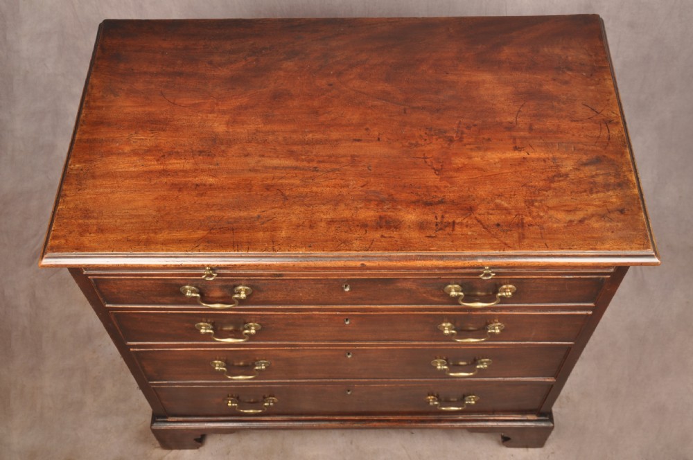 An eighteenth-century mahogany chest of drawers featuring four graduated drawers with brass swan-neck handles, a brushing slide, and bracket feet. View IX