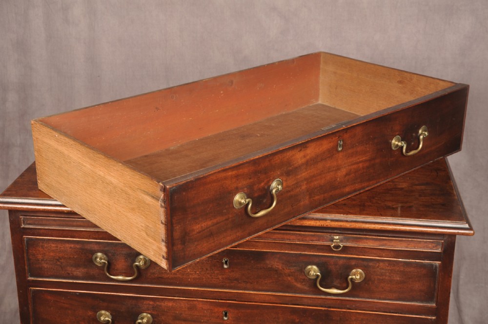An eighteenth-century mahogany chest of drawers featuring four graduated drawers with brass swan-neck handles, a brushing slide, and bracket feet. View X
