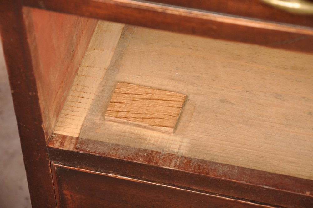 An eighteenth-century mahogany chest of drawers featuring four graduated drawers with brass swan-neck handles, a brushing slide, and bracket feet. View XI