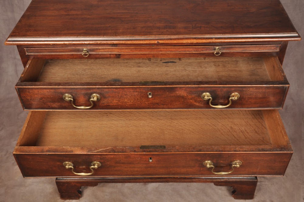 An eighteenth-century mahogany chest of drawers featuring four graduated drawers with brass swan-neck handles, a brushing slide, and bracket feet. View XII