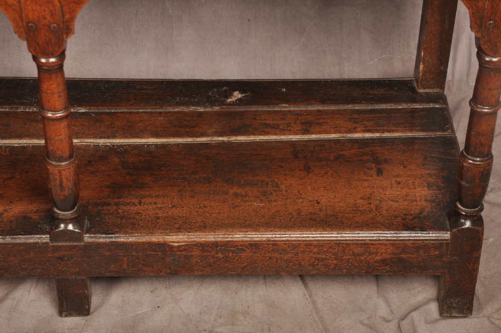 An 18th-century oak pot board dresser featuring an open tiered plate rack above three drawers with brass handles and a low shelf. View VII