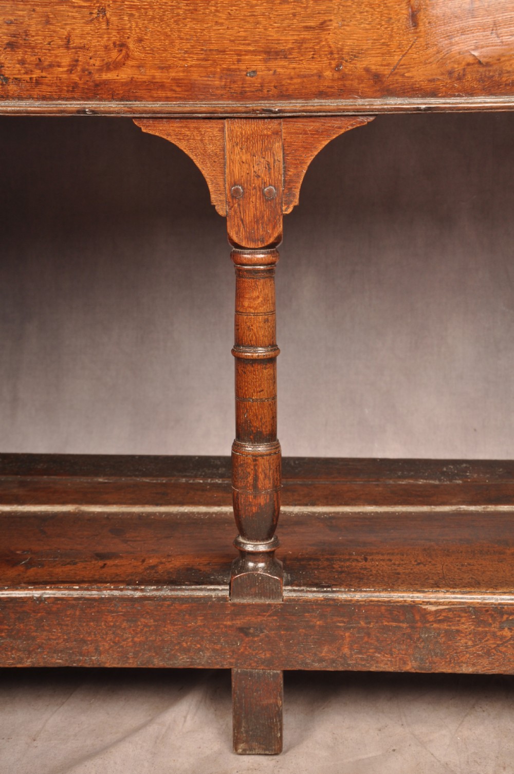 An 18th-century oak pot board dresser featuring an open tiered plate rack above three drawers with brass handles and a low shelf. View X