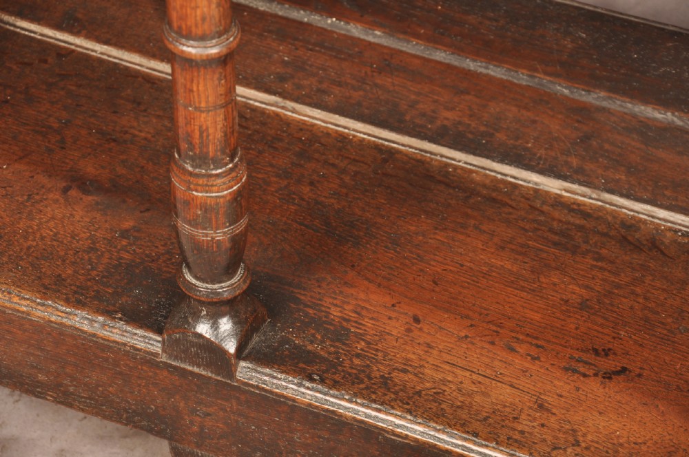 An 18th-century oak pot board dresser featuring an open tiered plate rack above three drawers with brass handles and a low shelf. View XV